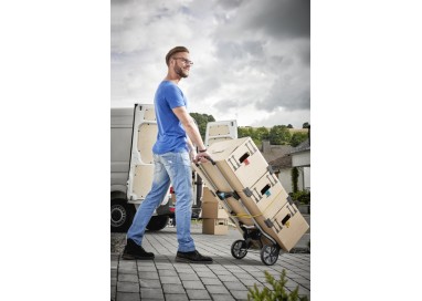 Hombre transportando cajas pesadas con la carretilla Wolfcraft TS 850.