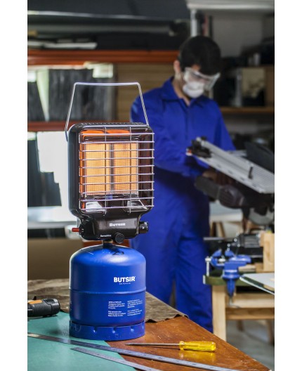 Estufa de gas butano para camping conectada a botella azul en taller de trabajo