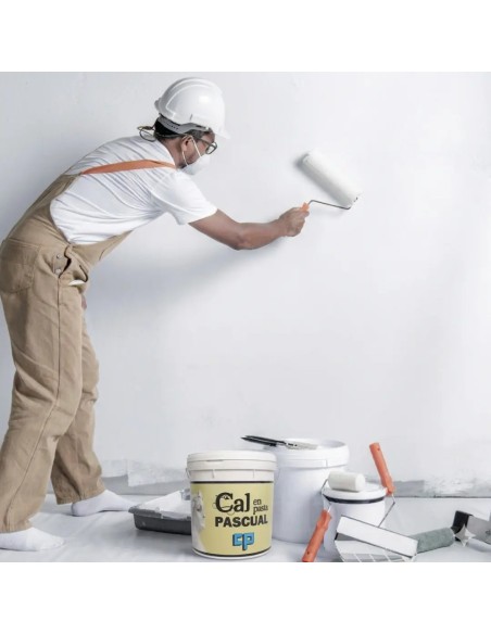 hombre pintando pared con cal en pasta