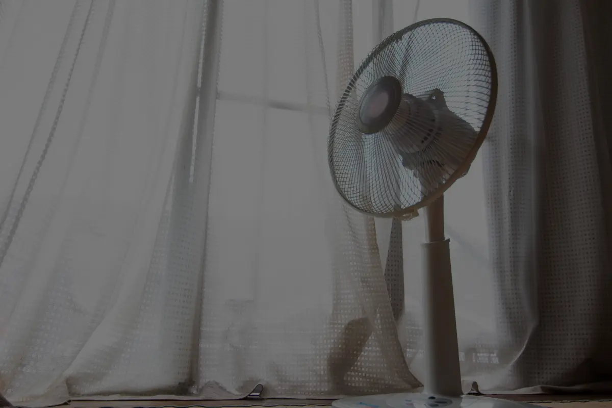 ventilador en habitacion al lado de ventana con cortina