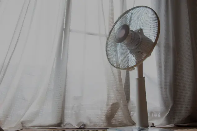 ventilador en habitacion al lado de ventana con cortina